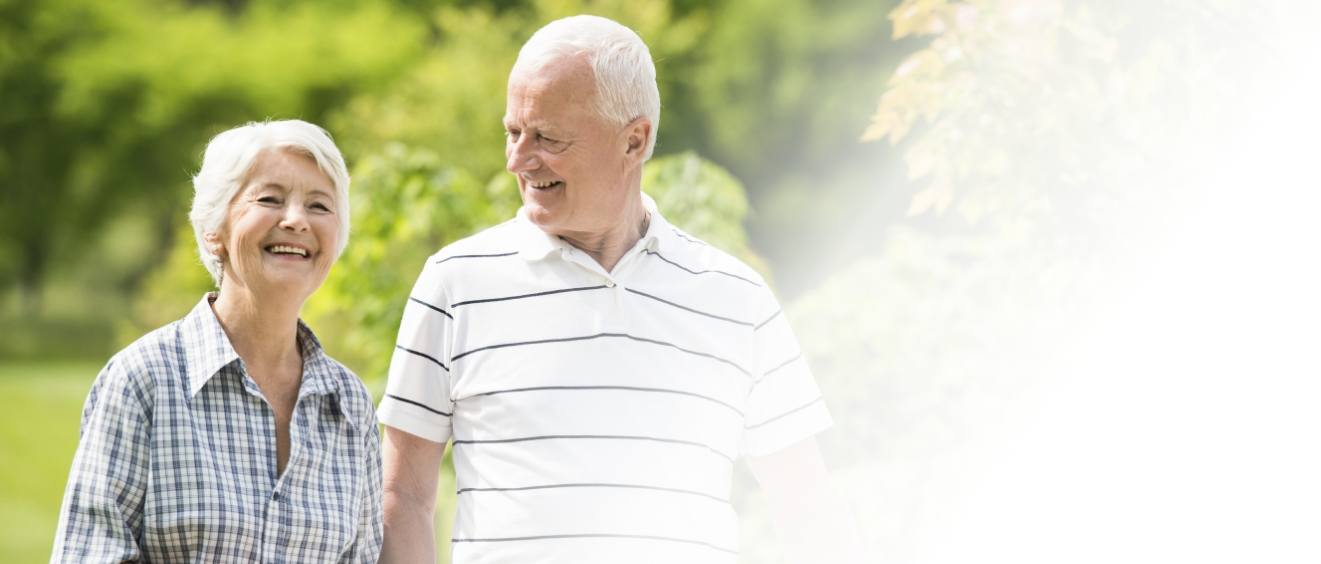 Senior man and woman walking outdoors and smiling