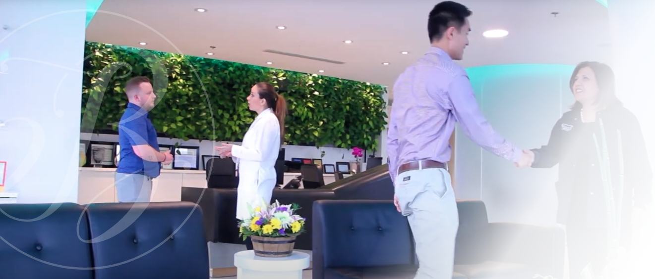 Patients shaking hands with periodontist and team member