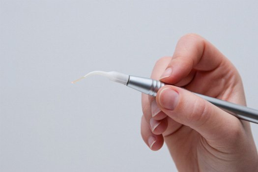 Closeup of hand holding laser dental instrument