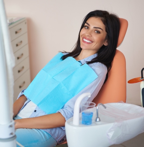 Smiling woman leaning back in the dental chair