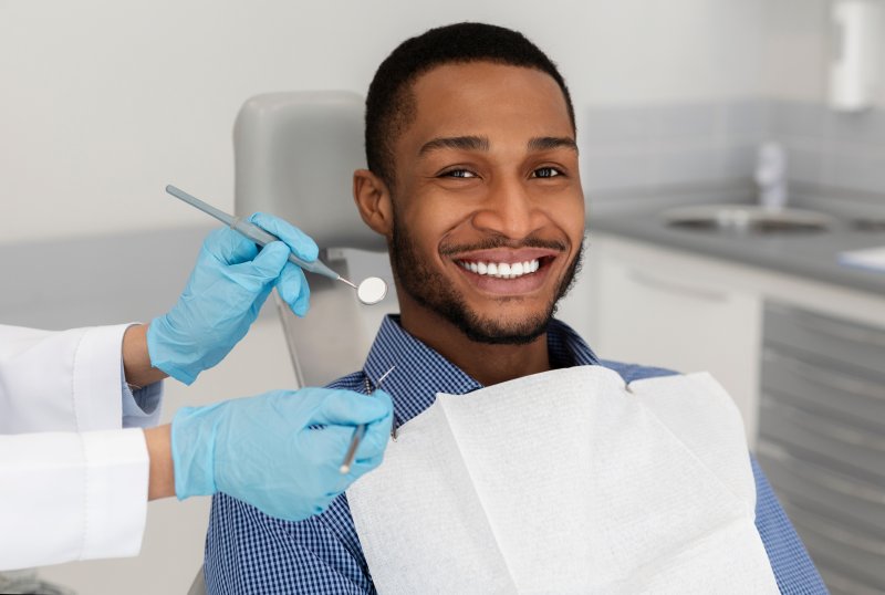 a patient smiling while visiting his dentist